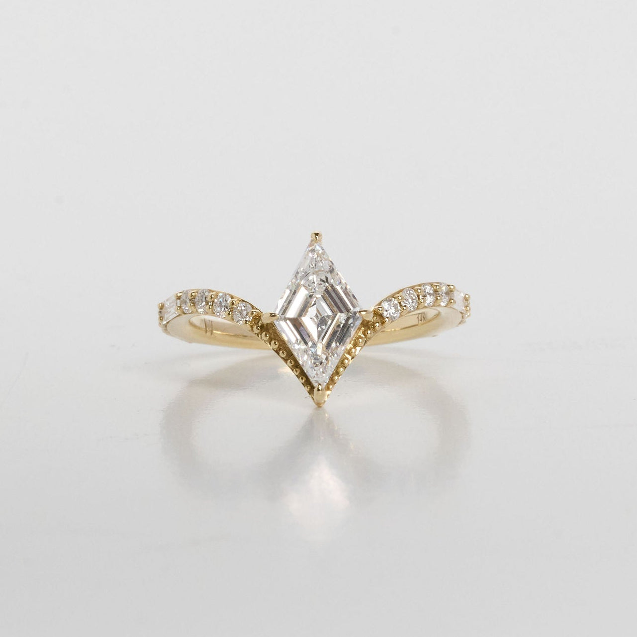 Gold ring with a diamond on a light gray background