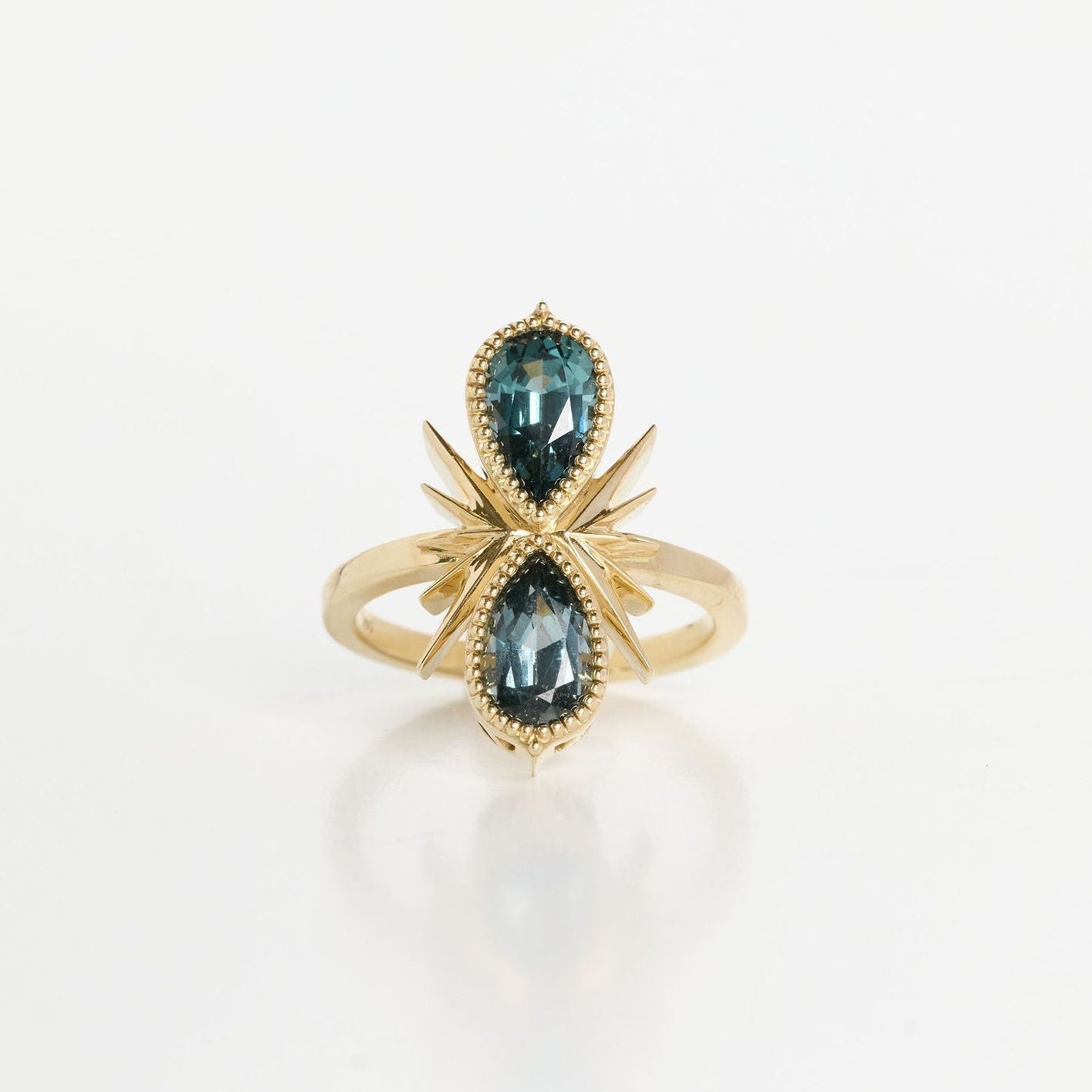 Gold ring with blue gemstones on a white background
