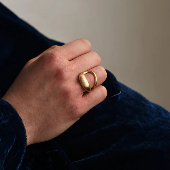 close up of model wearing the brass drip ring on their ring finger