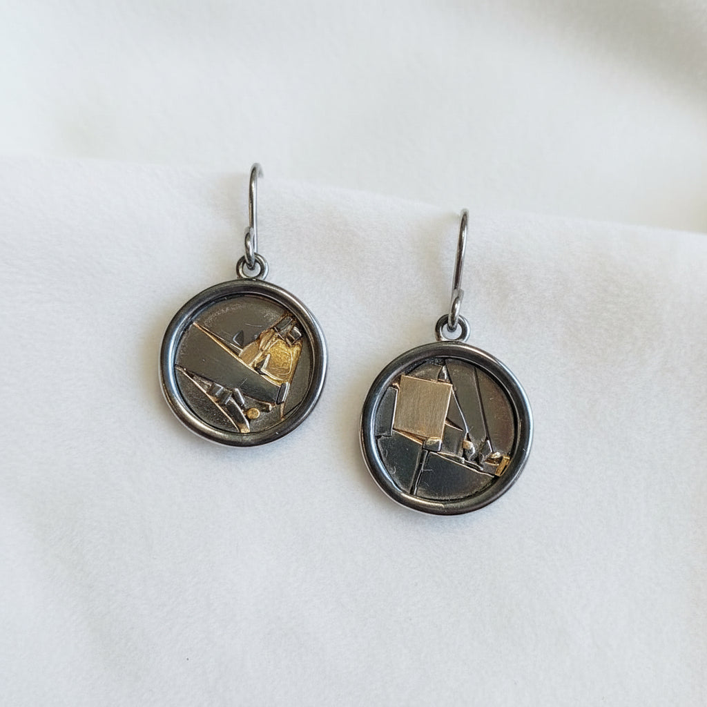 Pair of earrings with circular designs on a black background