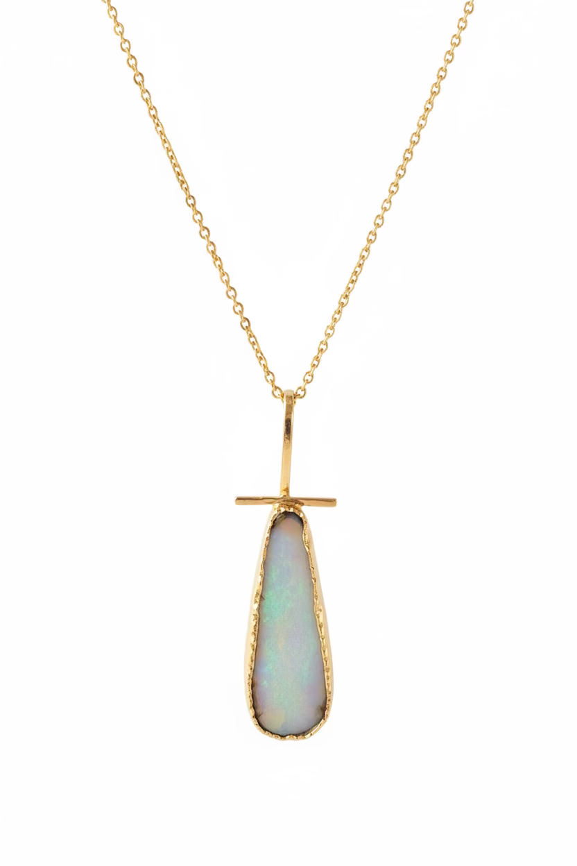 Necklace with a gold pendant featuring a blue gemstone on a black background