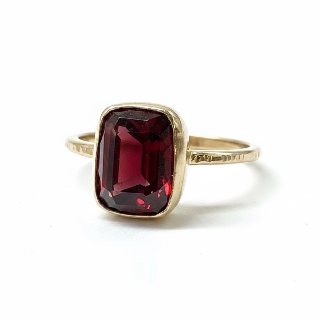 Gold ring with a red gemstone on a textured gray background