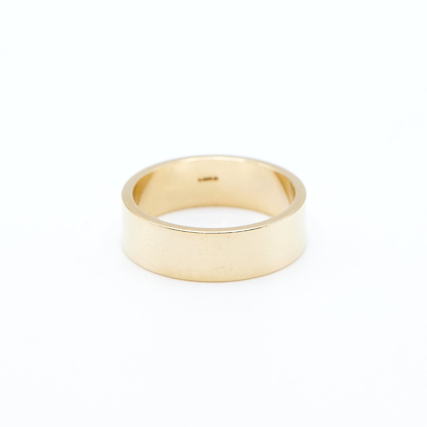 flat profile yellow gold wedding band with a high polish finish on a white background