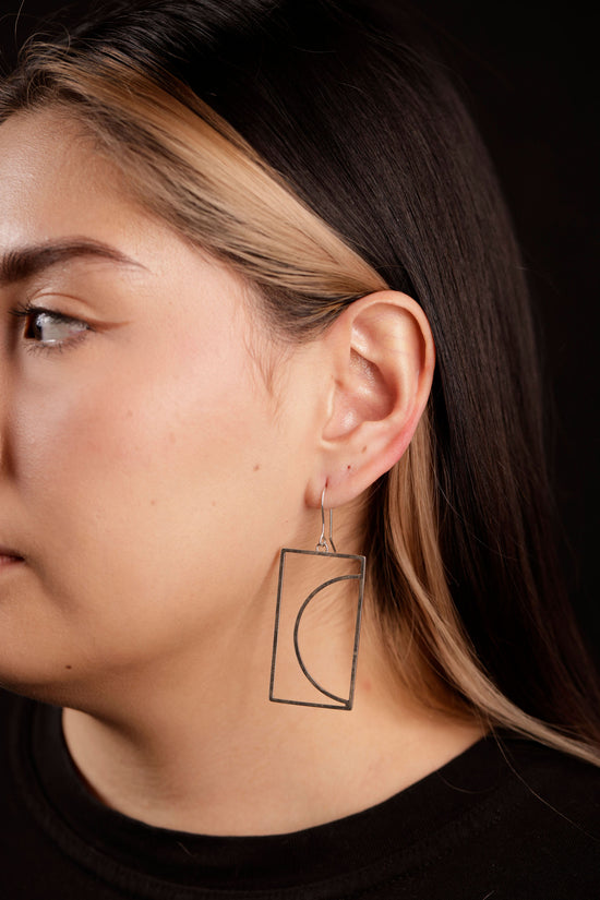 arco dangle earrings on model