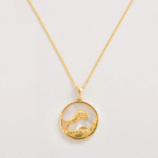 "Leo" gold color necklace on an off white background 