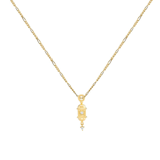 a gold lantern shaped pendant with white diamonds accents on a figaro chain on a white background