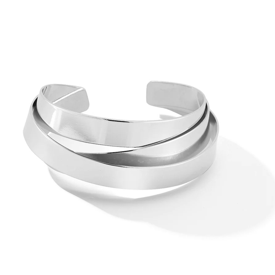 silver sculptural, intertwining metal cuff bracelet on white background