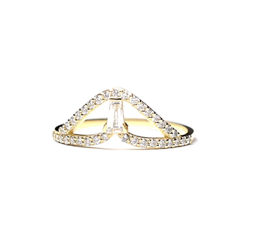 an arced yellow gold ring with round diamond details and one tapered baguette diamond in the center on a white background 