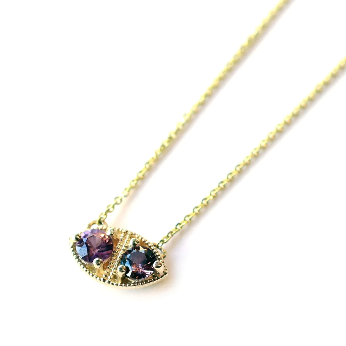 Load image into Gallery viewer, a marquise shaped pendant necklace with two round purple spinel stones and milgrain details close up on a white background
