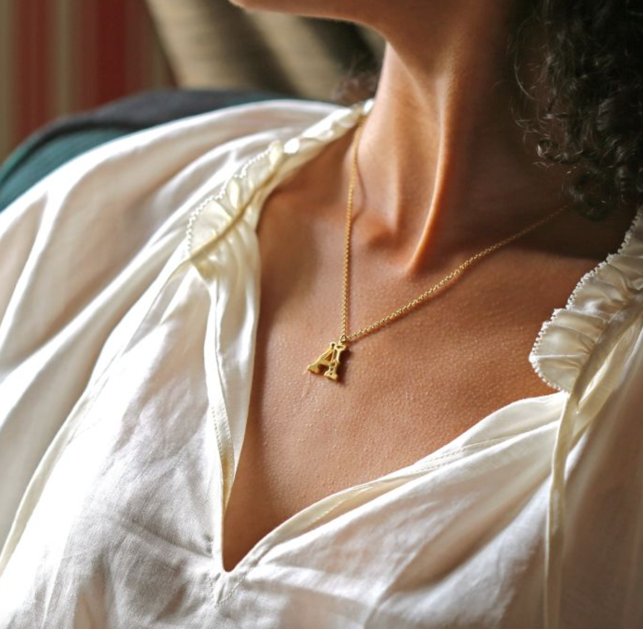close up of model wearing the A gothic initial pendant