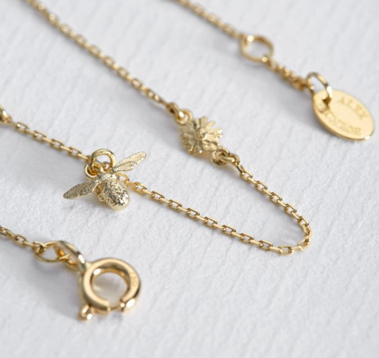close up details on the bumble bee and flower charm on the beekeeper floral chain bracelet 