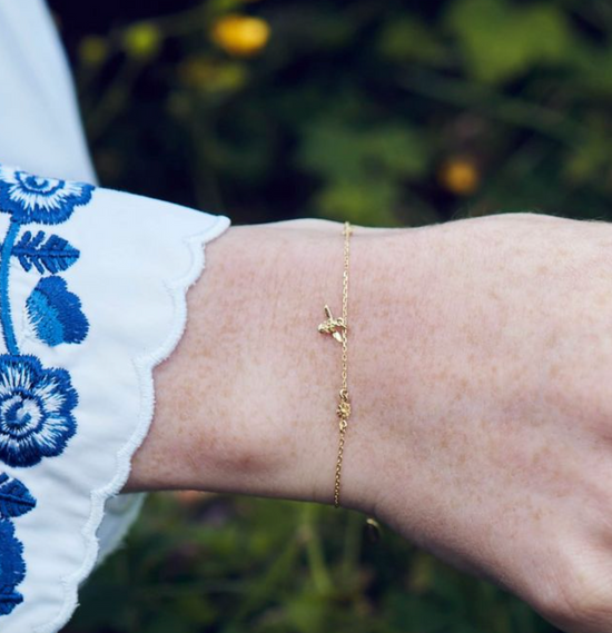 close up of model wearing the beekeeper floral chain bracelet