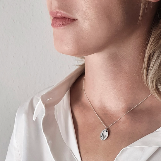 Load image into Gallery viewer, model wearing the silver hand motif pendant 
