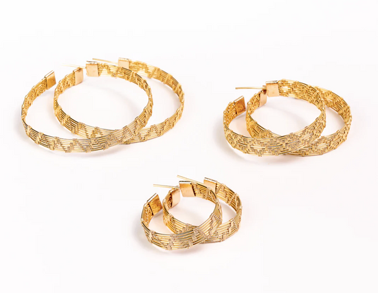 three varying sized woven gold hoop earrings on white background