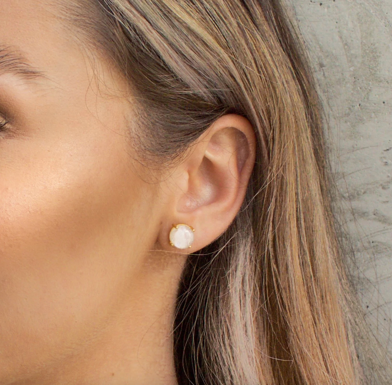 close up of a model wearing the rainbow moonstone studs