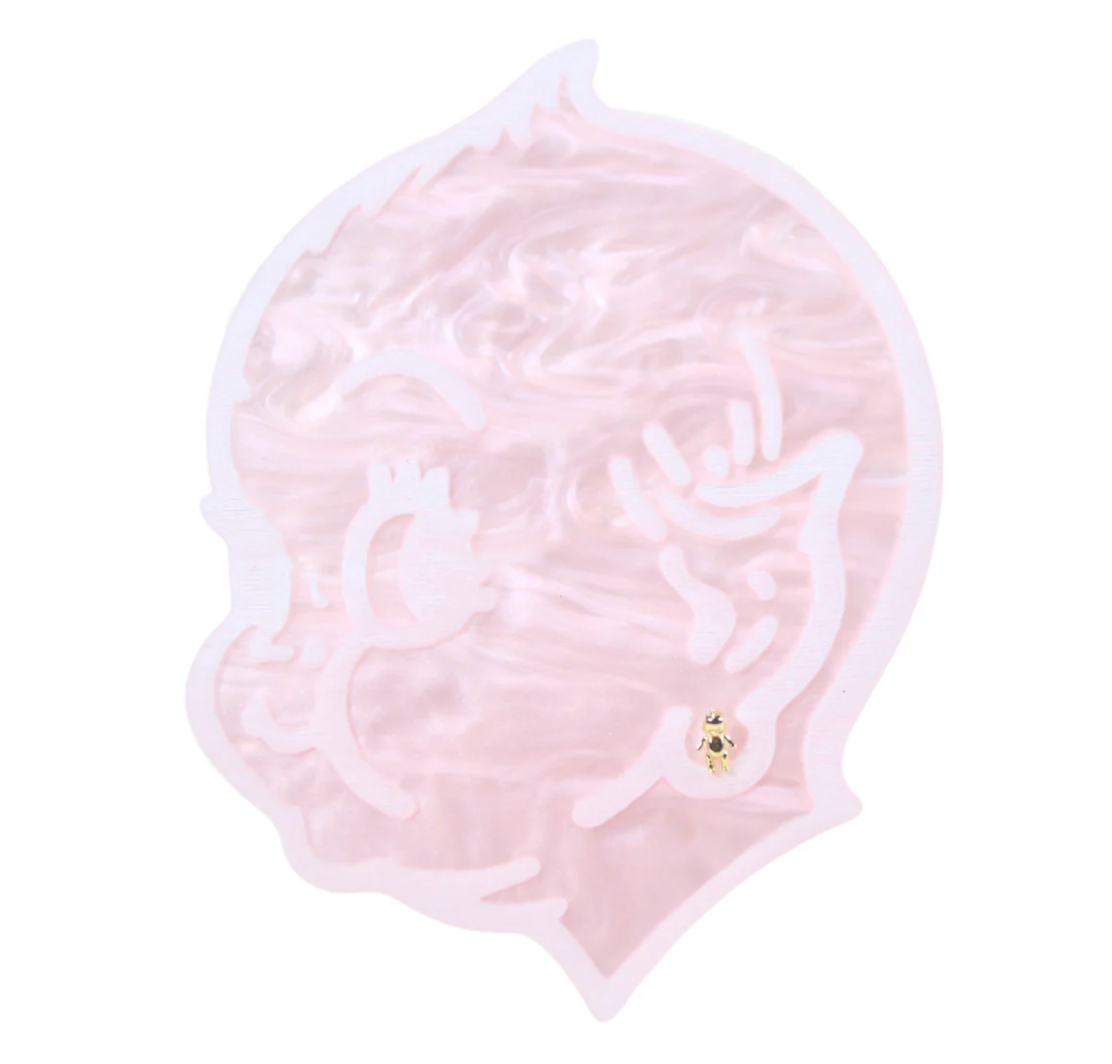 pink kewpie baby head wearing a tiny gold kewpie baby stud earring on a white background