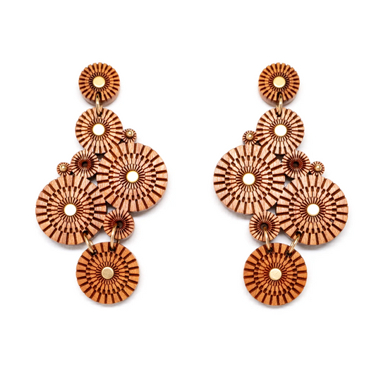 mirrored wooden statement earrings made up of multiple geometric engraved circles and brass details on a white background