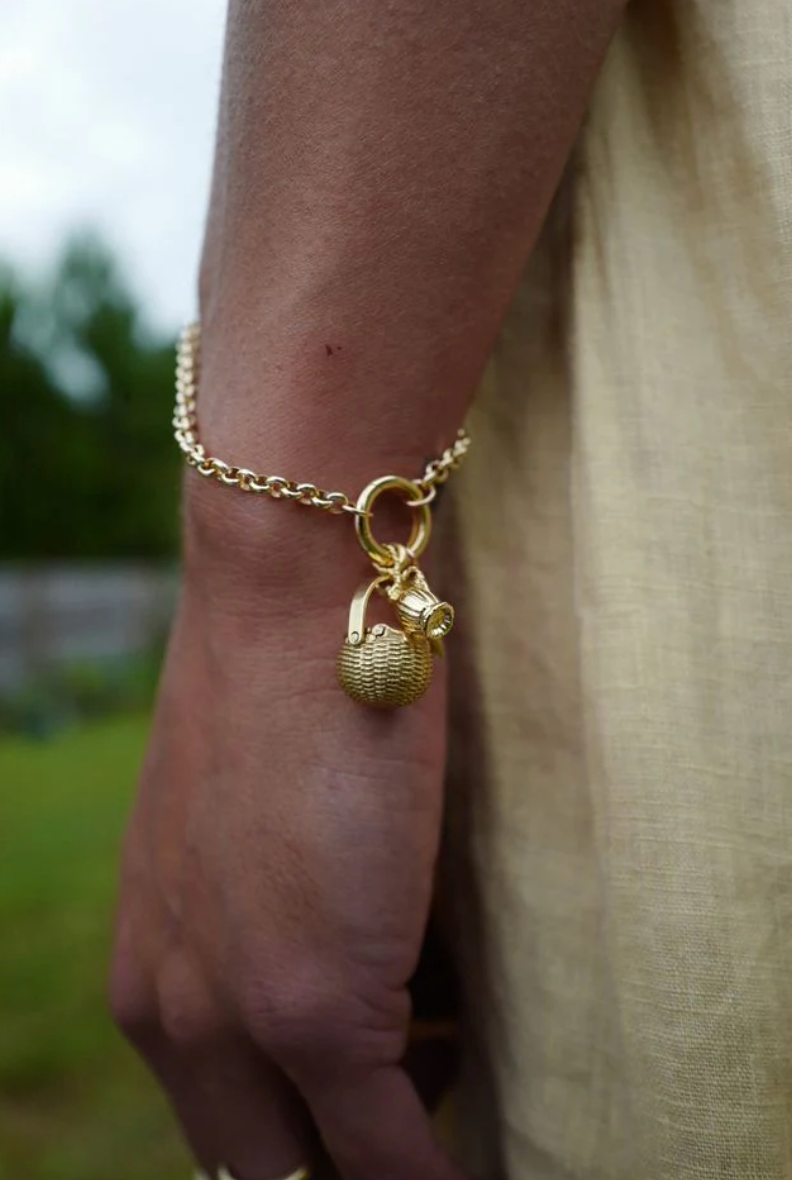 close up of a model wearing the charm clip bracelet with gold charms attached