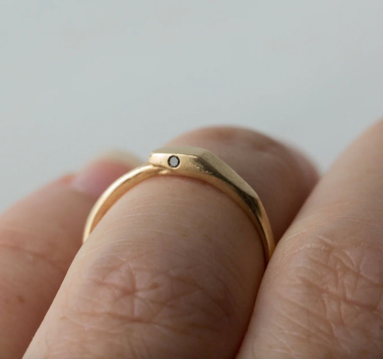 close up of model wearing the ouroboros ring with black diamond eyes