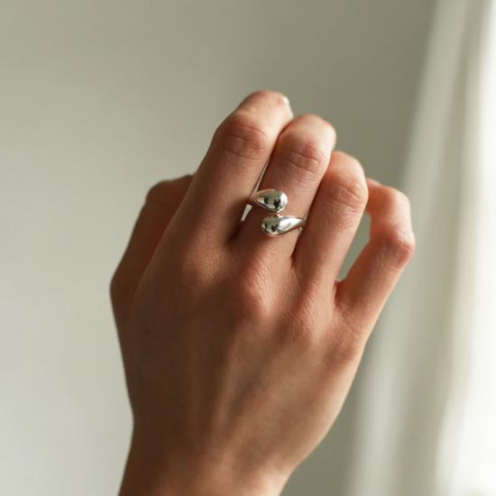 close up of a model wearing the silver drip ring on their middle finger