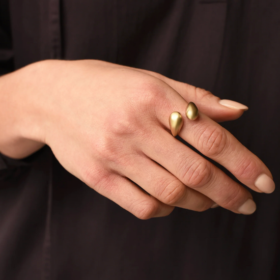 close up of a model wearing the brass drip ring on their pointer finger