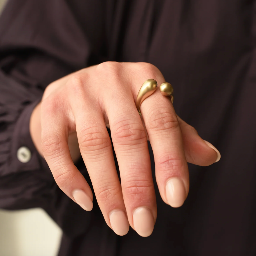 close up of front view of brass drip ring on model's pointer finger