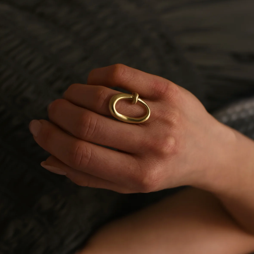 close up of a model wearing the brass oval ring on their ring finger