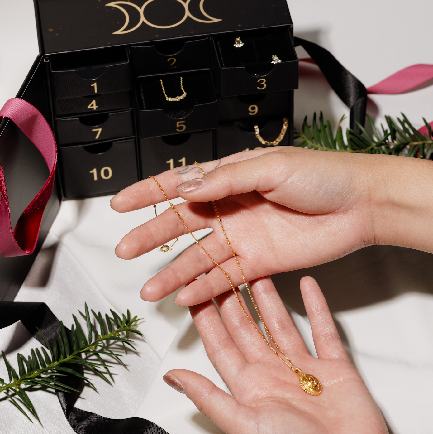 Advent Calendar on white background with model holding a necklace