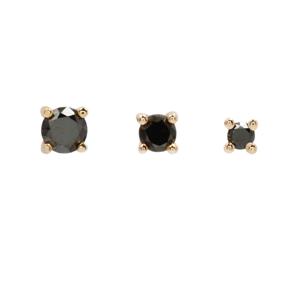 three black diamond round stud earrings in descending sizes on a white background
