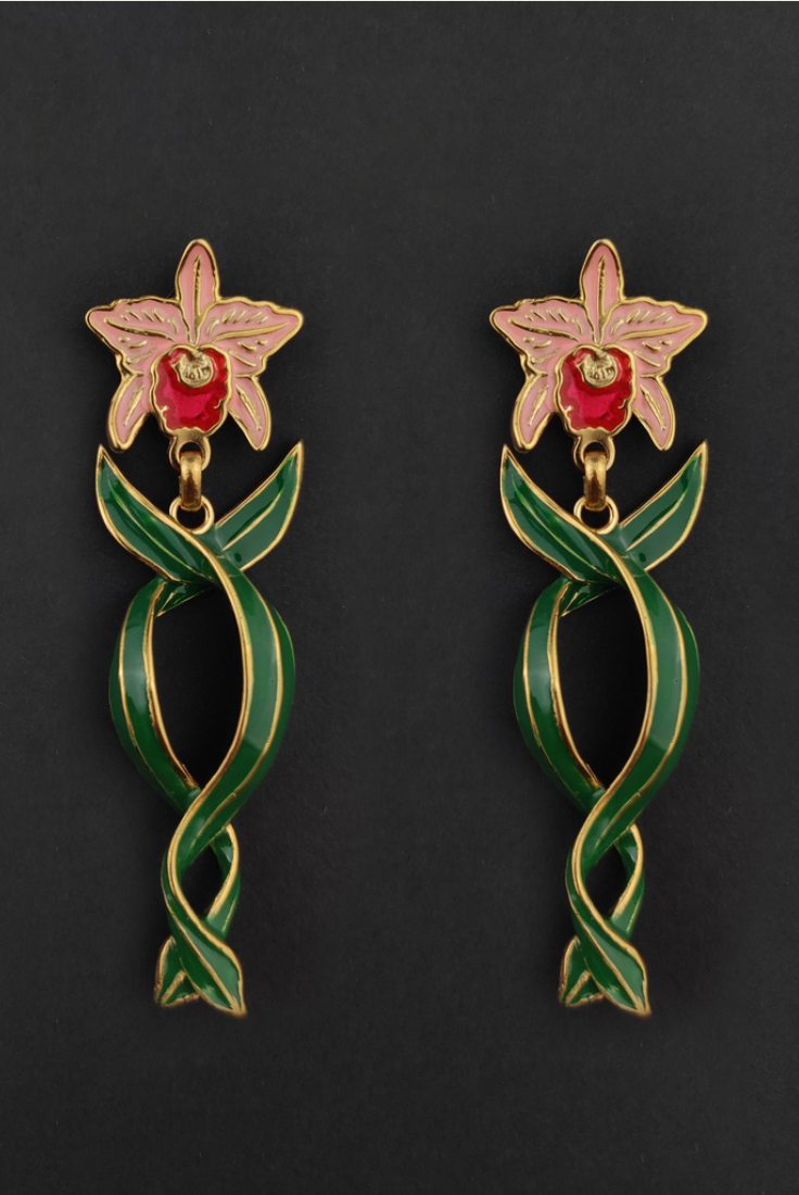 a christmas orchid earring with twisting leaves on a black background