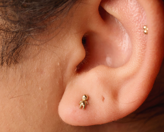 close up of a model wearing the kewpie baby stud in gold