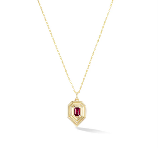 geometric teardrop shaped gold pendant with emerald cut ruby center stone on white background