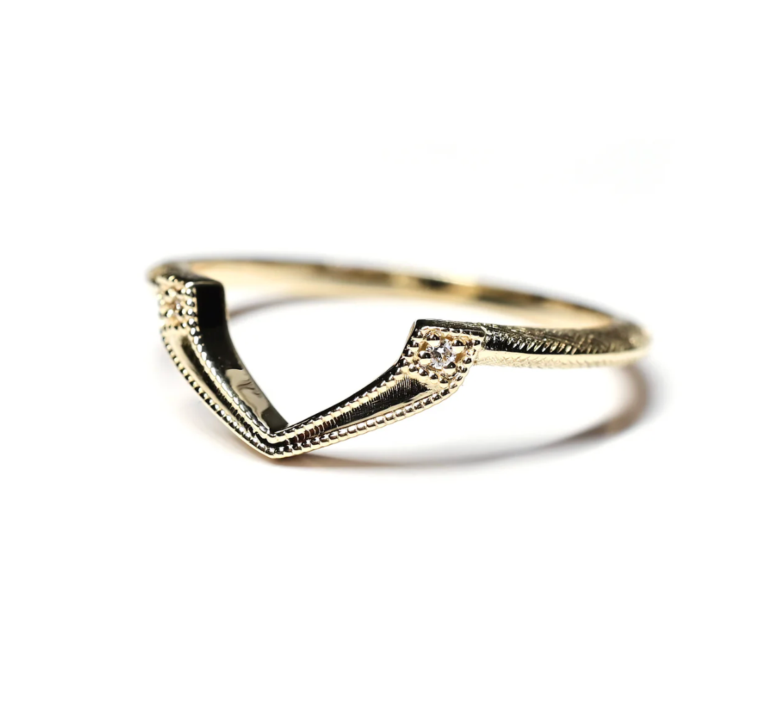 Gold ring with a V-shaped design on a white background