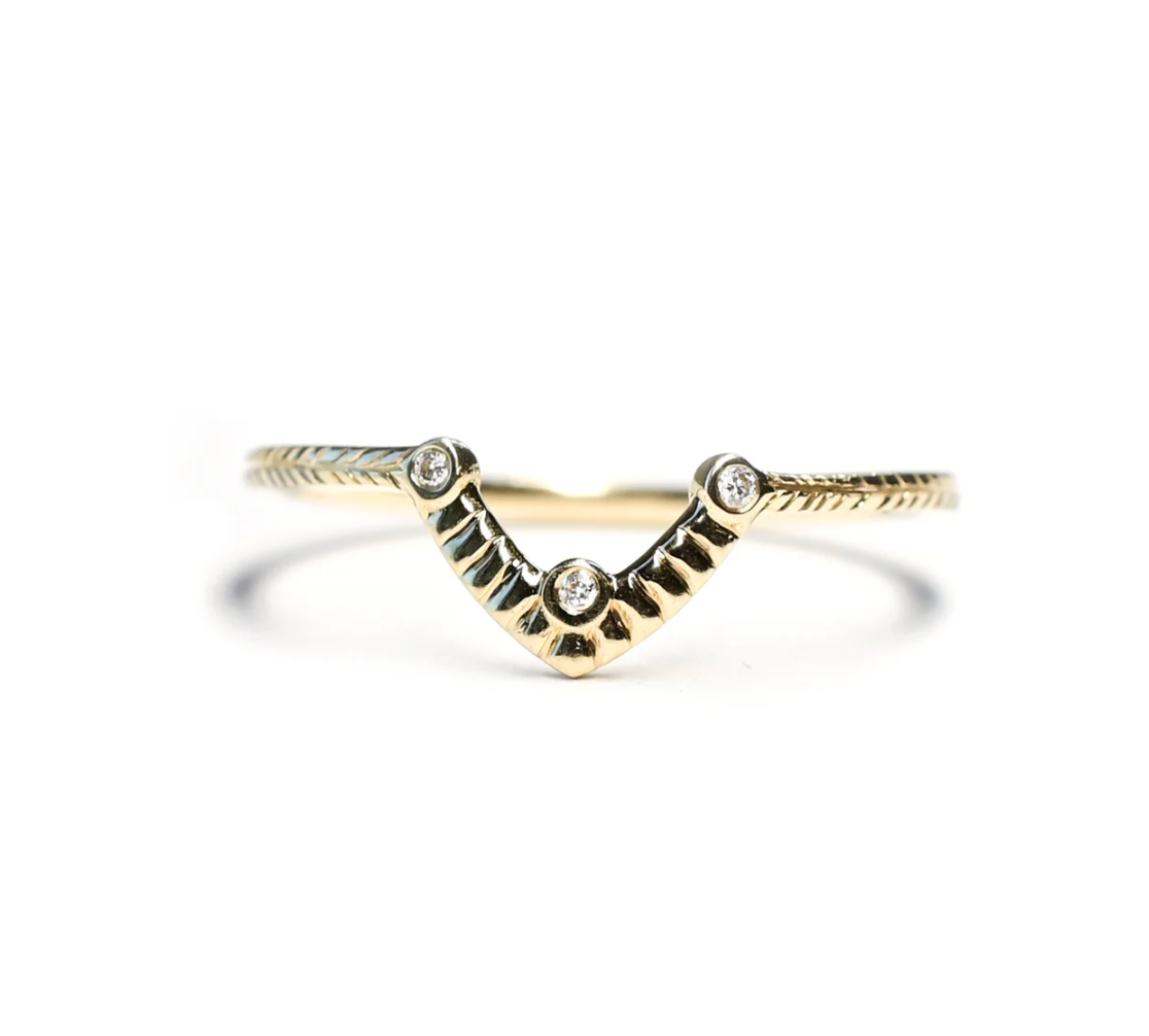 Gold ring with diamond accents on a white background