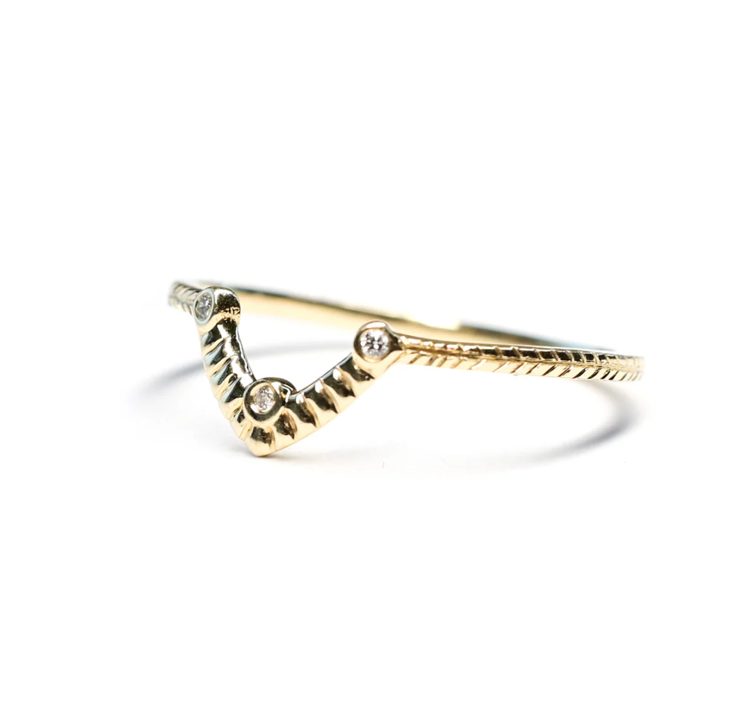 Gold ring with diamond accents on a white background