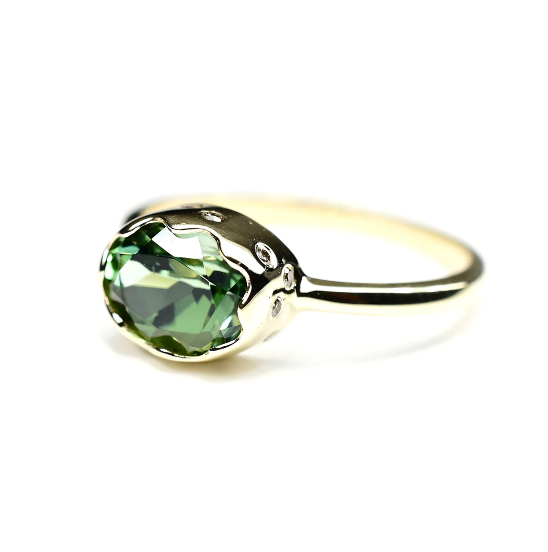 Gold ring with a green gemstone on a white background