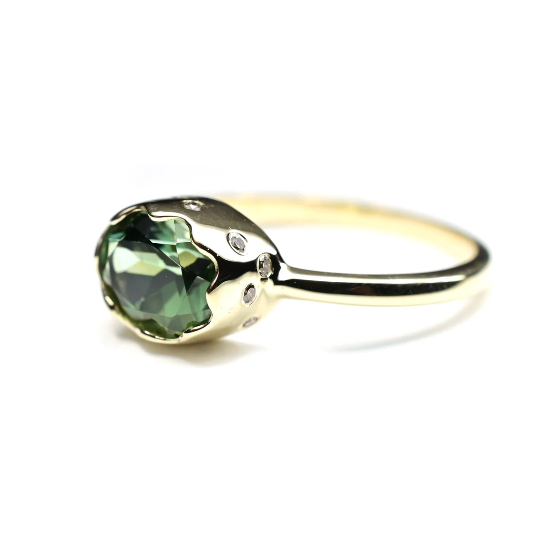 Gold ring with a green gemstone on a white background