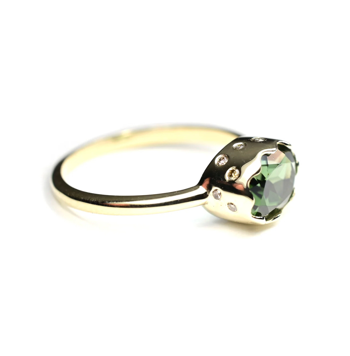 Gold ring with a green gemstone on a white background