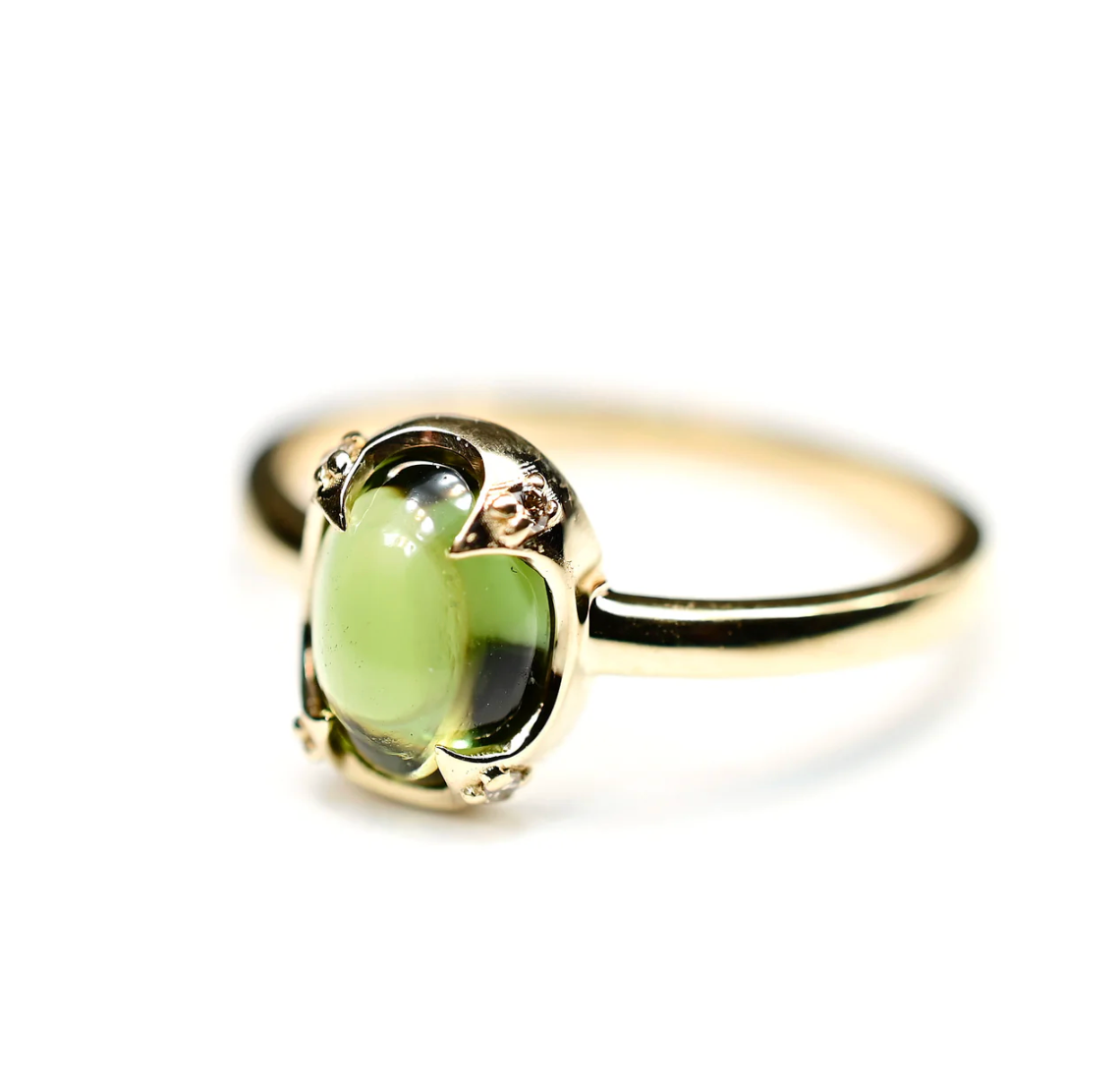 Gold ring with a green gemstone on a white background