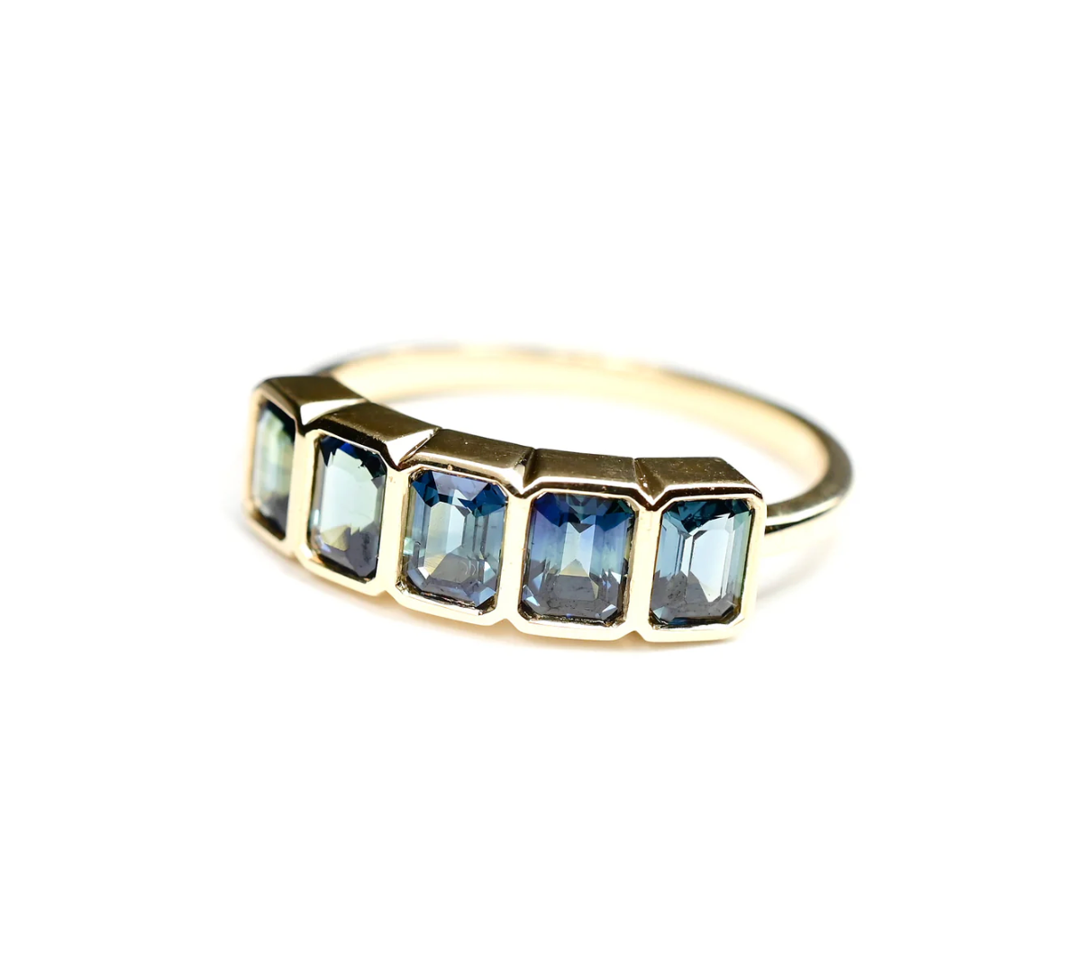 Gold ring with blue gemstones on a white background