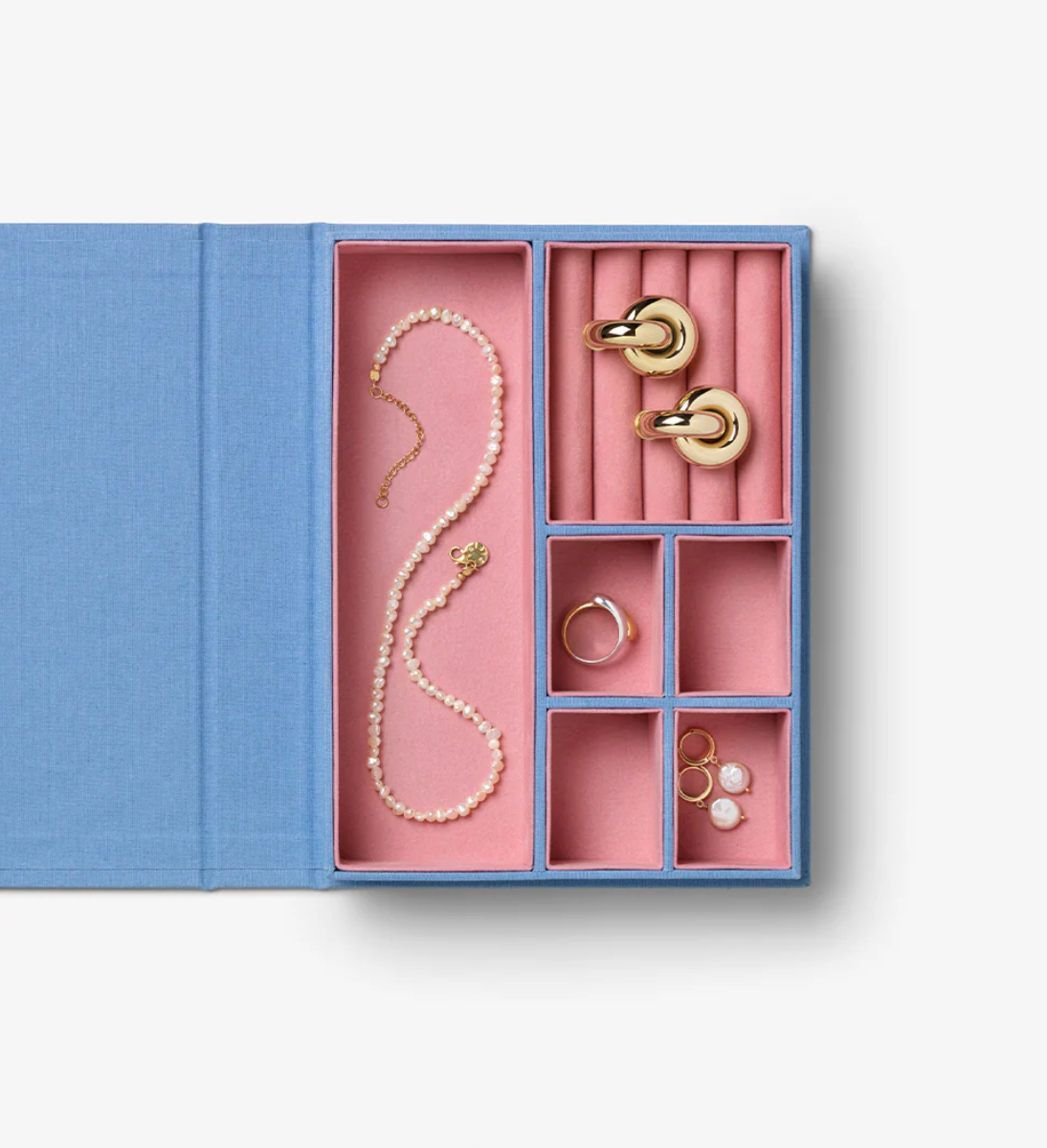 Jewelry set including a necklace, earrings, and rings in a pink jewelry box with blue exterior.