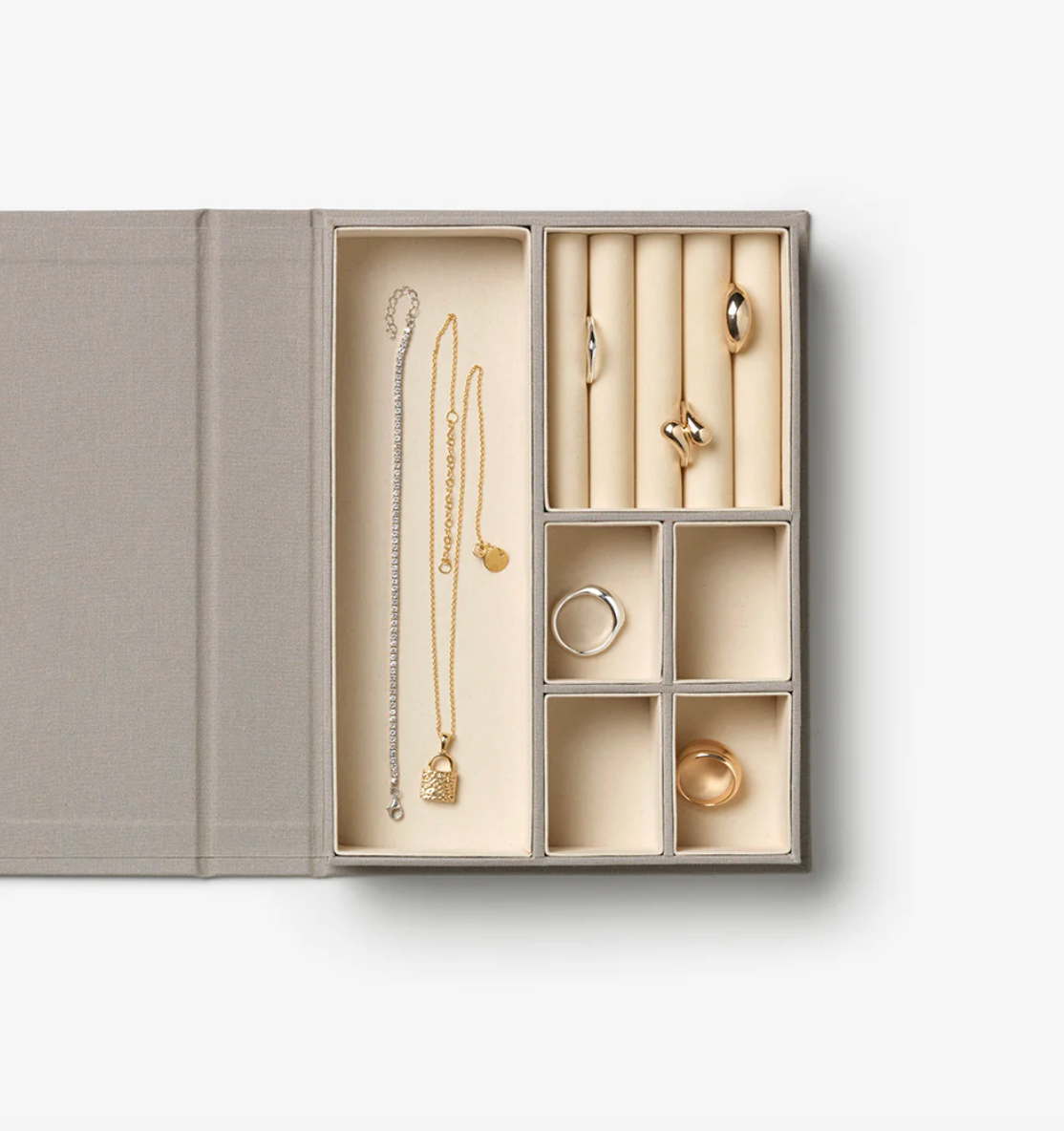 Jewelry set with necklaces and rings in an open jewelry box on a white background