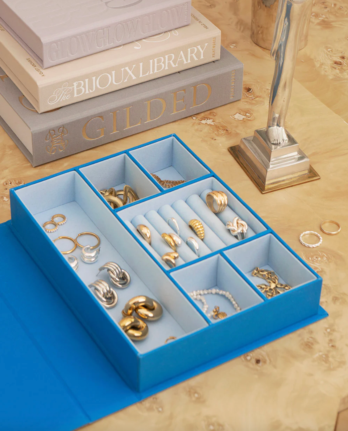 Blue jewelry organizer with rings on a wooden surface