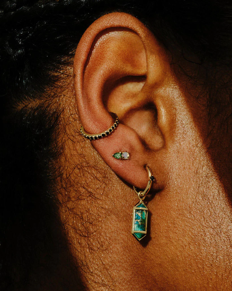 close up of ear with dangle earring, stud earring, and ear cuff