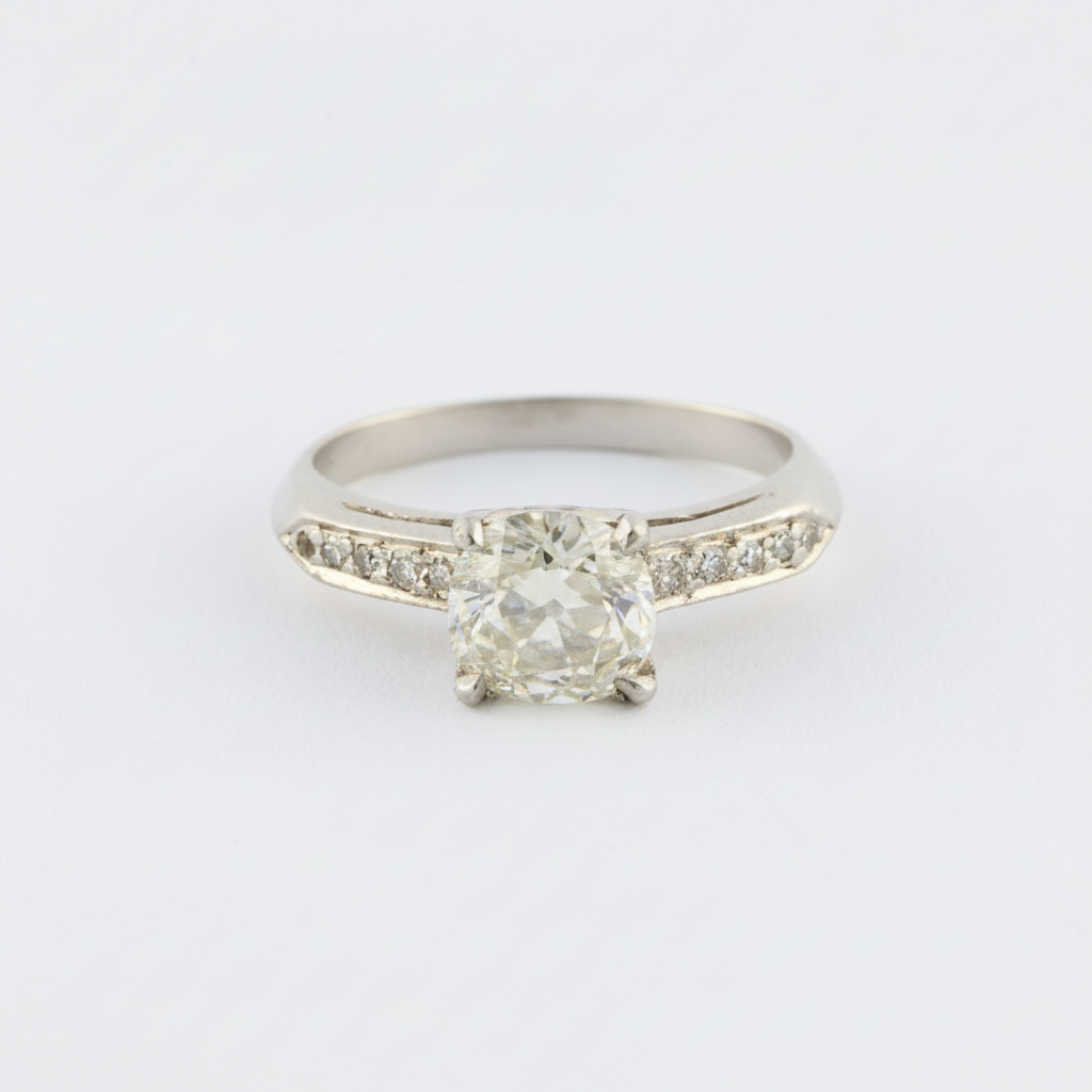 Diamond ring with a large central gemstone and smaller stones on a white background