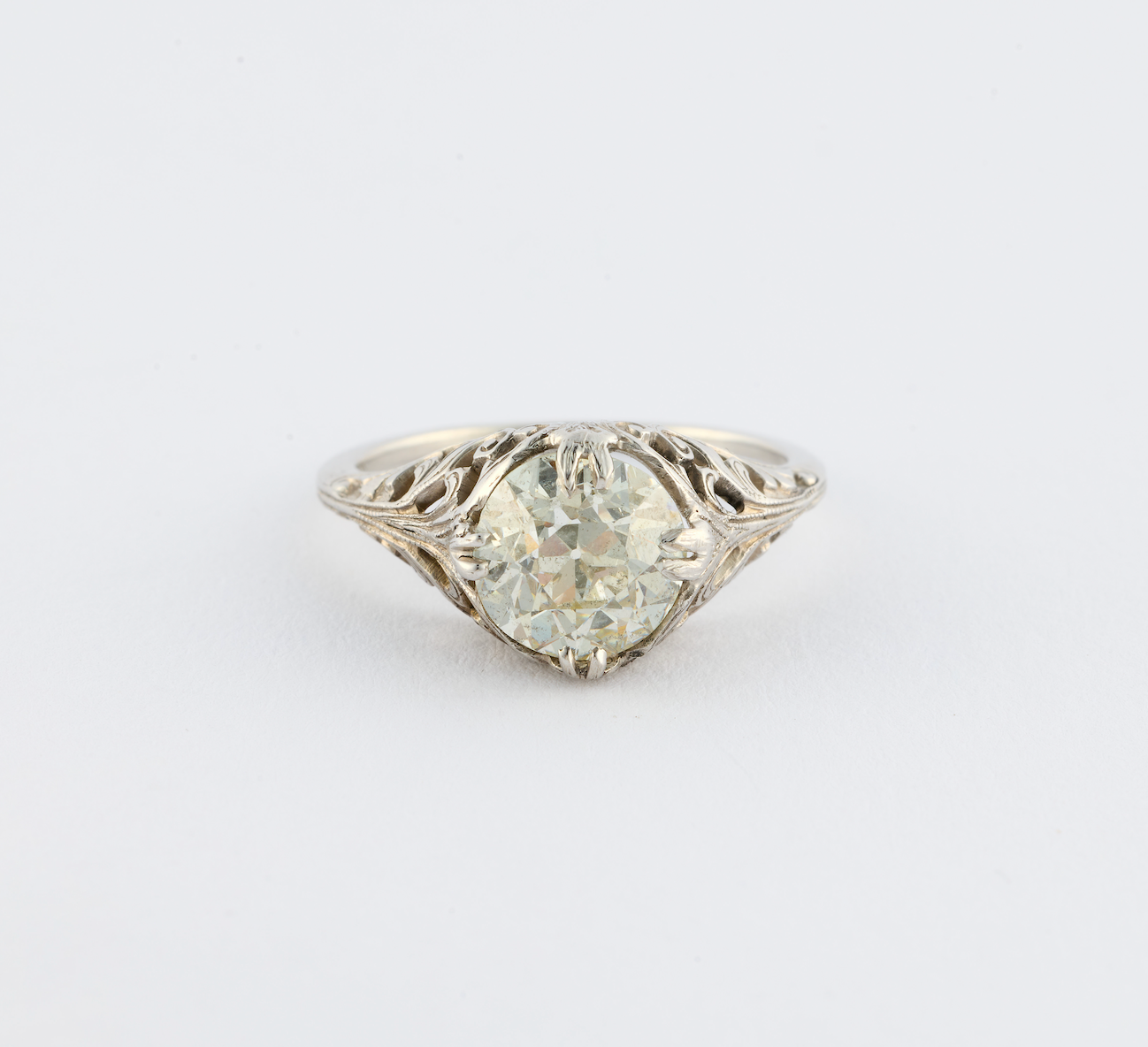 Diamond ring with intricate band on a light gray background