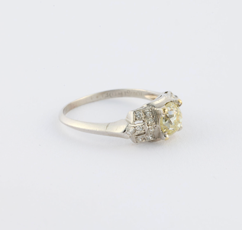 Silver ring with a large central gemstone and smaller stones on a white background