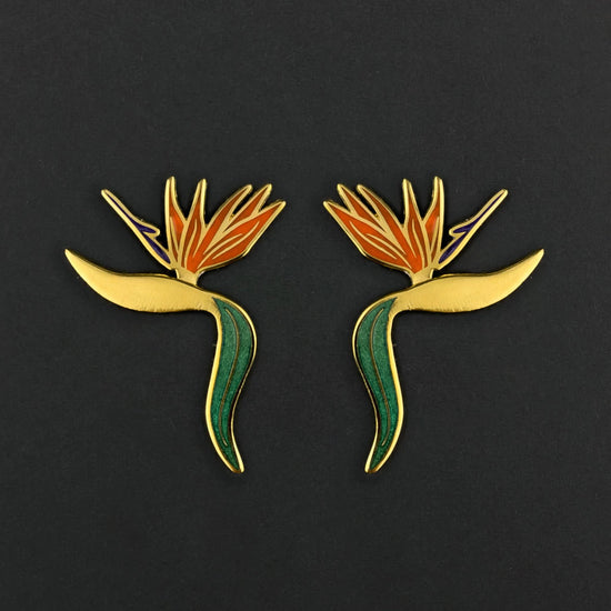 Pair of bird-of-paradise flower earrings on a black background