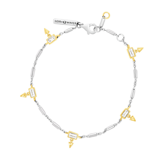 Silver and gold bracelet with geometric designs on a white background