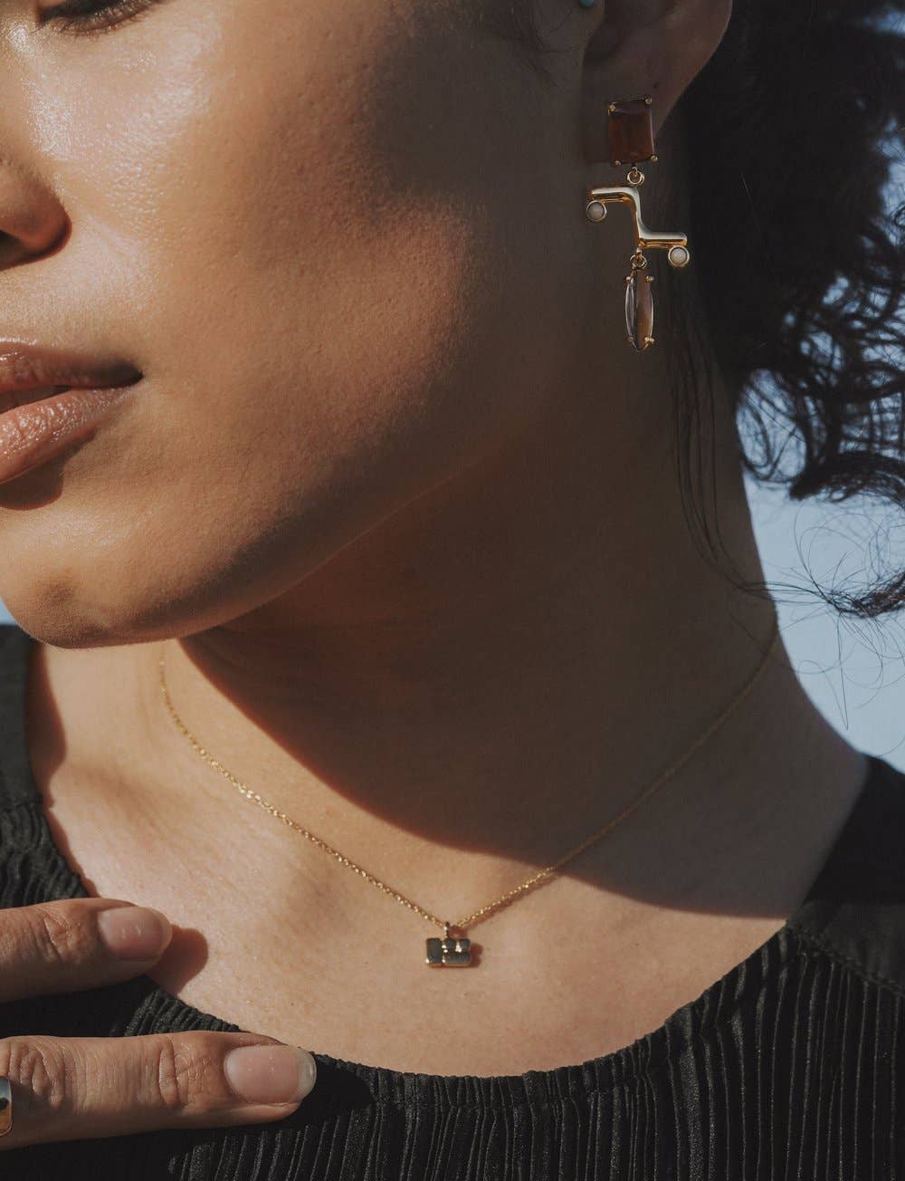 model wearing the pearson earrings and a small gold pendant necklace